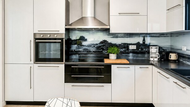 A modern kitchen with stainless steel appliances, white cabinetry, and a cityscape backsplash. - Stunning home in Porec (Porec)