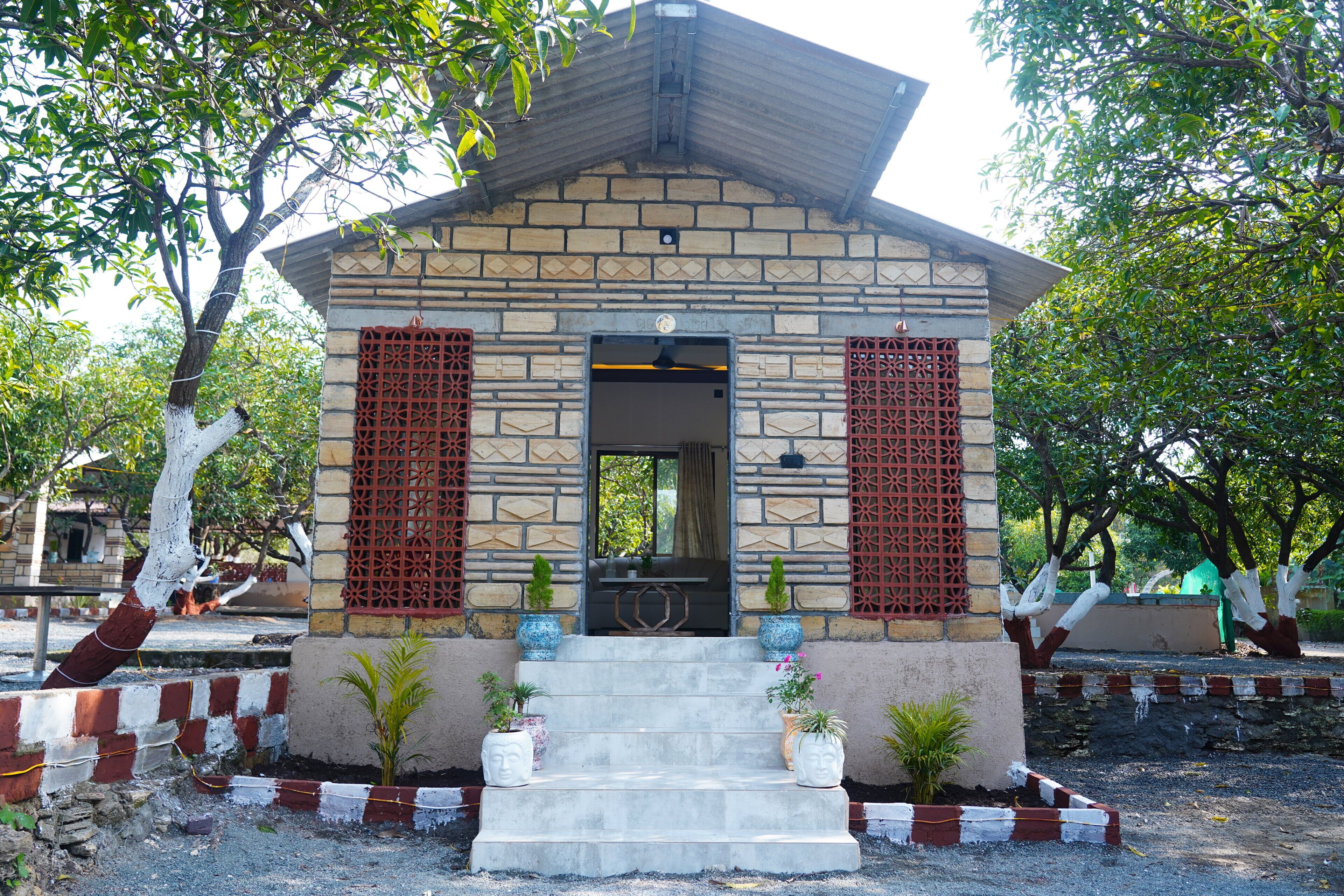 Un pequeño edificio de piedra con techo de tejas, una puerta y una escalera que lleva a él.