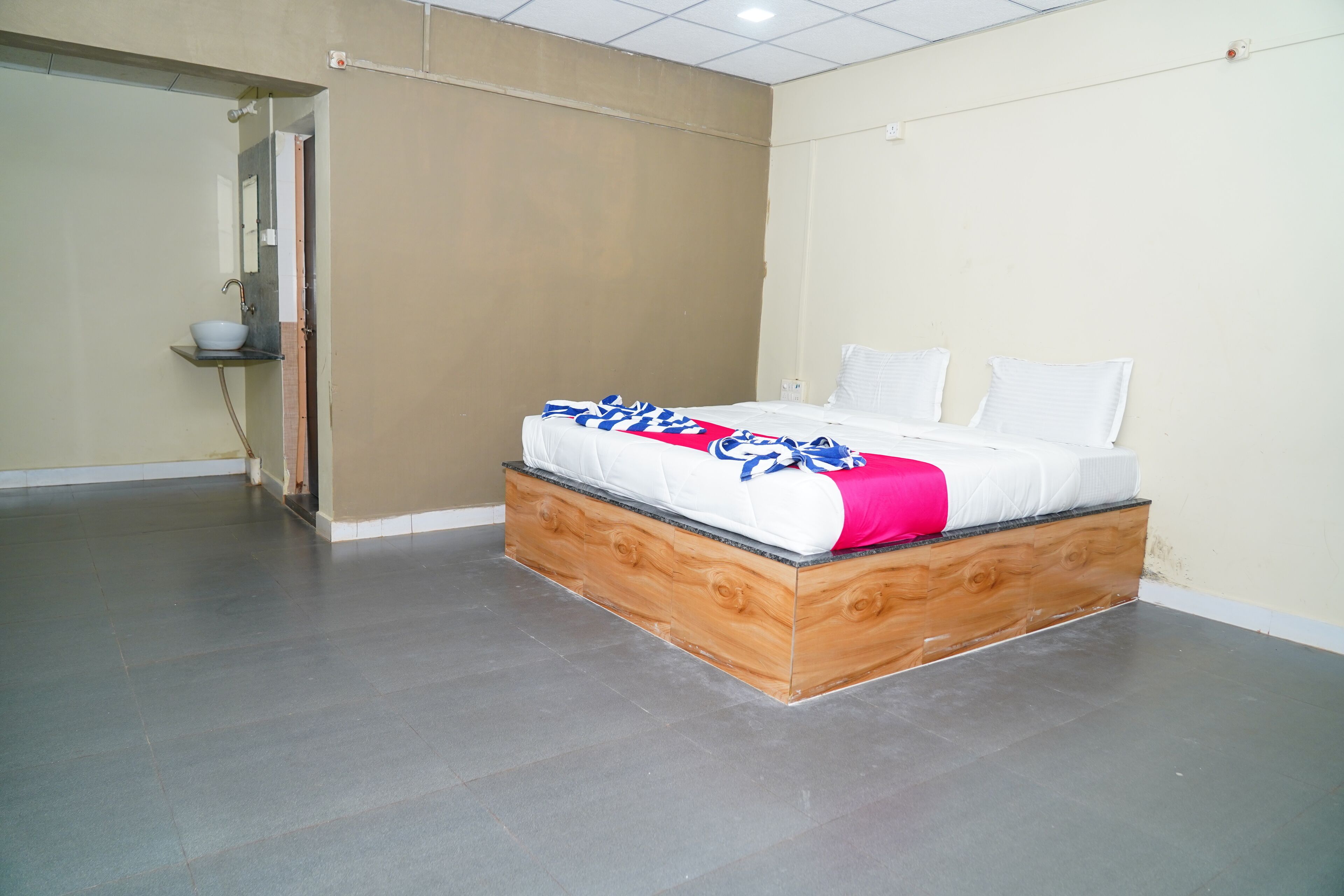 Un dormitorio con cama, mesita de noche y puerta al baño.