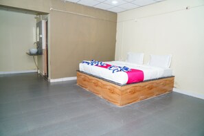 A bedroom with a bed, a nightstand, and a bathroom door.