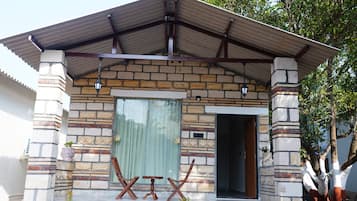 Ein Haus mit einer Steinaußenwand, einem Metall-Dach und einer Holztür.