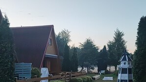 Une propriété rurale comprenant une maison en bois, une cour clôturée et un nichoir.