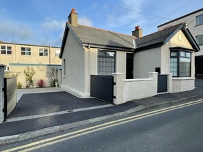A residential property with a garage, a driveway, and a small garden area. - The Cottage - Centre of Newcastle Co.Down (Newcastle)
