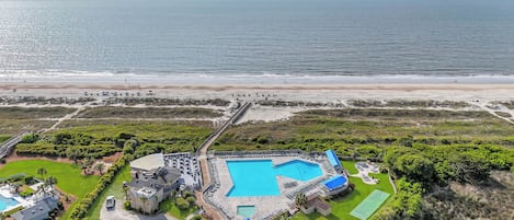 Un resort con una amplia piscina, playa y campo de golf.
