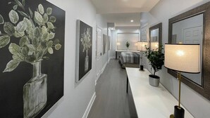 A hallway with artwork on the walls, a lamp, and a bed in the background. -     Oakville Executive Luxury Residence| 4BR • 7QB• 5 Ensuites • 2 Kitchens (Oakville)