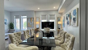 A dining area with a large table surrounded by upholstered chairs, a television, and artwork on the walls. -     Oakville Executive Luxury Residence| 4BR • 7QB• 5 Ensuites • 2 Kitchens (Oakville)