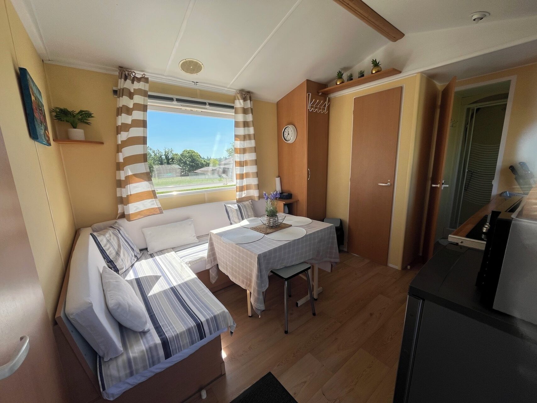 Una habitación funcional con cama, una mesa de comedor y kitchenette.