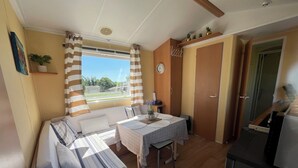 Ein gemütlicher Raum mit Bett, Esstisch und Küchenzeile.