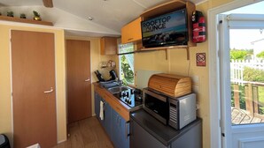 Eine kompakte Küchenzeile mit Mikrowelle, Herd und einem Schild, das eine Dachterrasse ankündigt.