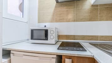 A kitchen with a microwave, induction cooktop, and a dishwasher.