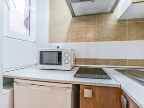 Eine Küche mit Mikrowelle, Induktionskochfeld und Geschirrspüler.