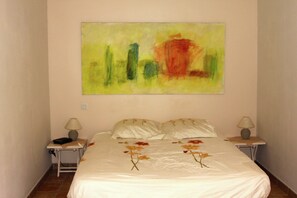 A bedroom with a bed, two bedside tables, and a large abstract painting on the wall. - Estate with Shared Pool & Boules Court (Valréas)