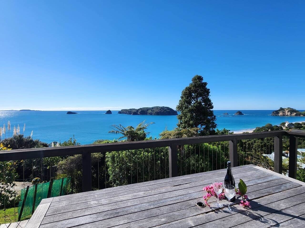 Una terraza de madera con vista al mar y a las islas.