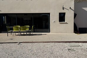 A building with a gravel ground, a glass door entrance, and a small window. - Villa with pool and jacuzzi near Châteauneuf-du-Pape – 13 people (Sorgues)