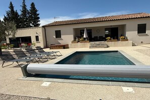 A swimming pool with lounge chairs and a building with a tiled roof. - Villa with pool and jacuzzi near Châteauneuf-du-Pape – 13 people (Sorgues)