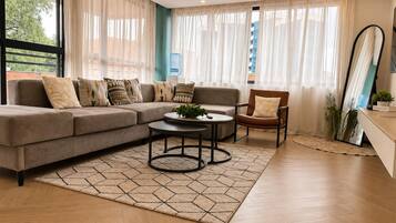 A modern living room with a sectional sofa, a round coffee table, and a leather armchair.