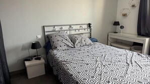 A hotel room with a bed, a bedside table, a lamp, a desk, and a mirror. - Villa with pool and jacuzzi near Châteauneuf-du-Pape – 9 people (Sorgues)