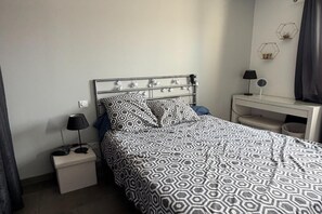 A hotel room with a bed, a bedside table, a lamp, a desk, and a mirror. - Villa with pool and jacuzzi near Châteauneuf-du-Pape – 9 people (Sorgues)