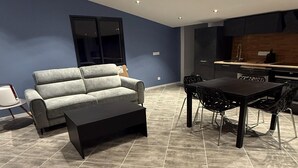 A modern living room with a sofa, coffee table, and dining area. - Villa with pool and jacuzzi near Châteauneuf-du-Pape – 4 people (Sorgues)