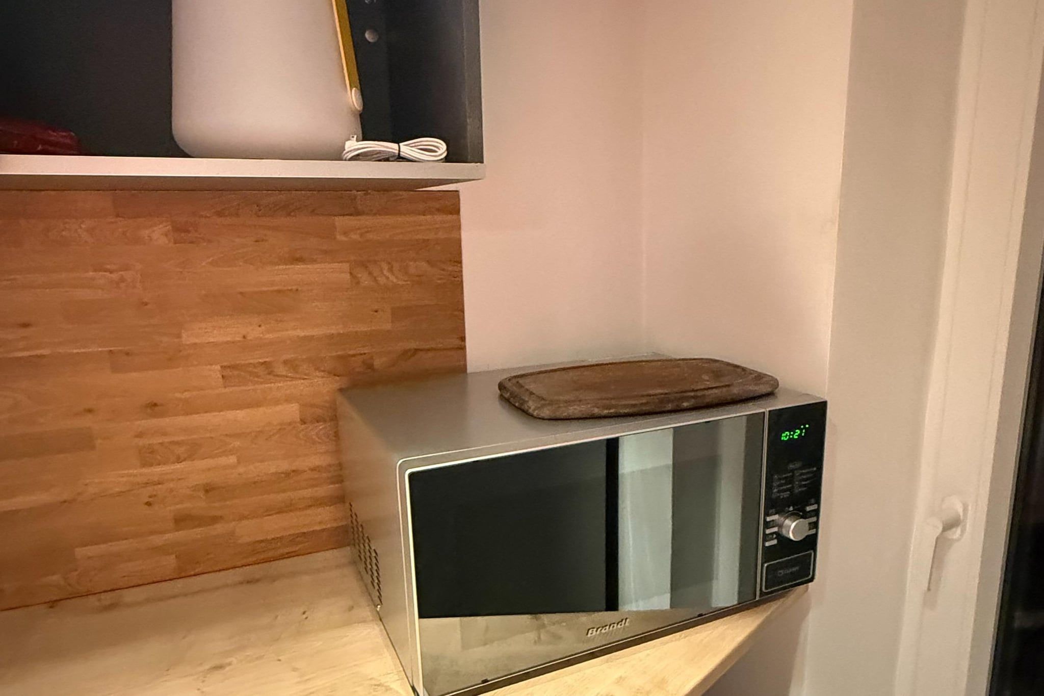 A microwave on a wooden countertop with a digital display.