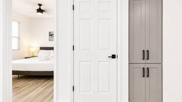 Een hotelkamer met een bed, een bedlampje en een garderobe met twee deuren.