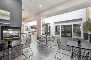 Amplio espacio interior con mesa de billar, zona de estar y ventanas grandes que ofrecen vistas al gimnasio.