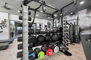 A gym with weightlifting equipment, including kettlebells, medicine balls, and dumbbells. - CozySuites Glendale - Westgate w pool! 1BR 1BA (Glendale)