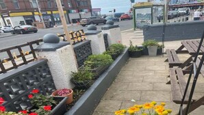 A rooftop terrace with planters, a trash bin, and a bench. - Standard Triple Room (Blackpool)