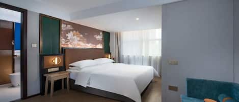 Una habitación de hotel con cama, mesita de noche, lámpara y vistas al exterior.