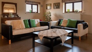 Een woonkamer met twee banken, een salontafel en een open haard.