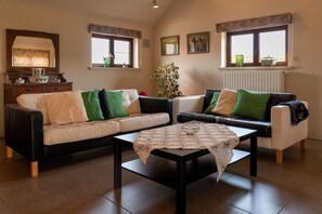A living room with two sofas, a coffee table, and a fireplace. - Apartment 3 – Enjoy a cozy stay at the Alfonsinehoeve (Horpmaal)