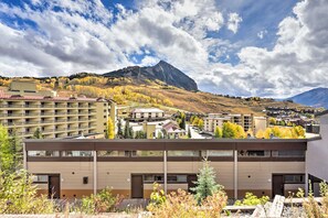 A multi-story building with a flat roof, located in a mountainous area with autumn foliage. - Snowcrest Condo | Walk to the Lifts (crested butte)
