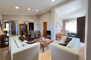 A spacious living room with a sofa set, a coffee table, and a television.