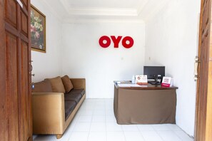 A room with a sofa, a desk, and a wall with the letters 'OYO' in red.