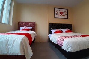 Dos camas individuales con ropa de cama roja y blanca, un logotipo en un marco en la pared y una ventana con cortinas.