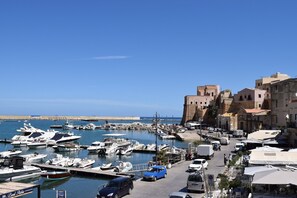A marina with boats docked, a clear sky, and buildings in the background. - Villa in Valderice with Pool and Garden (Valderice (TP))