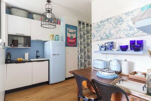 Eine kleine Küche mit Kühlschrank, Mikrowelle und einer Pendelleuchte.