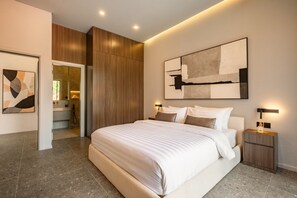 A modern bedroom with a large bed, wooden paneling, a contemporary abstract painting, and a nightstand with a lamp. - Cozy 2BR Villa in Umalas | Near Seminyak & Canggu (Umalas)
