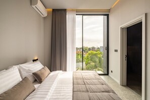 A modern bedroom with a bed, a sliding glass door to a balcony, and an air conditioning unit. - Cozy 2BR Villa in Umalas | Near Seminyak & Canggu (Umalas)