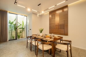 Un coin repas avec une table en bois dressée pour six personnes, entourée de chaises.