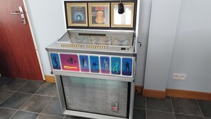 A jukebox with a selection of records, a door, and a tiled floor. - Charmante maison de 4 chambres avec salle de bain privative à Villersexel (Villersexel)