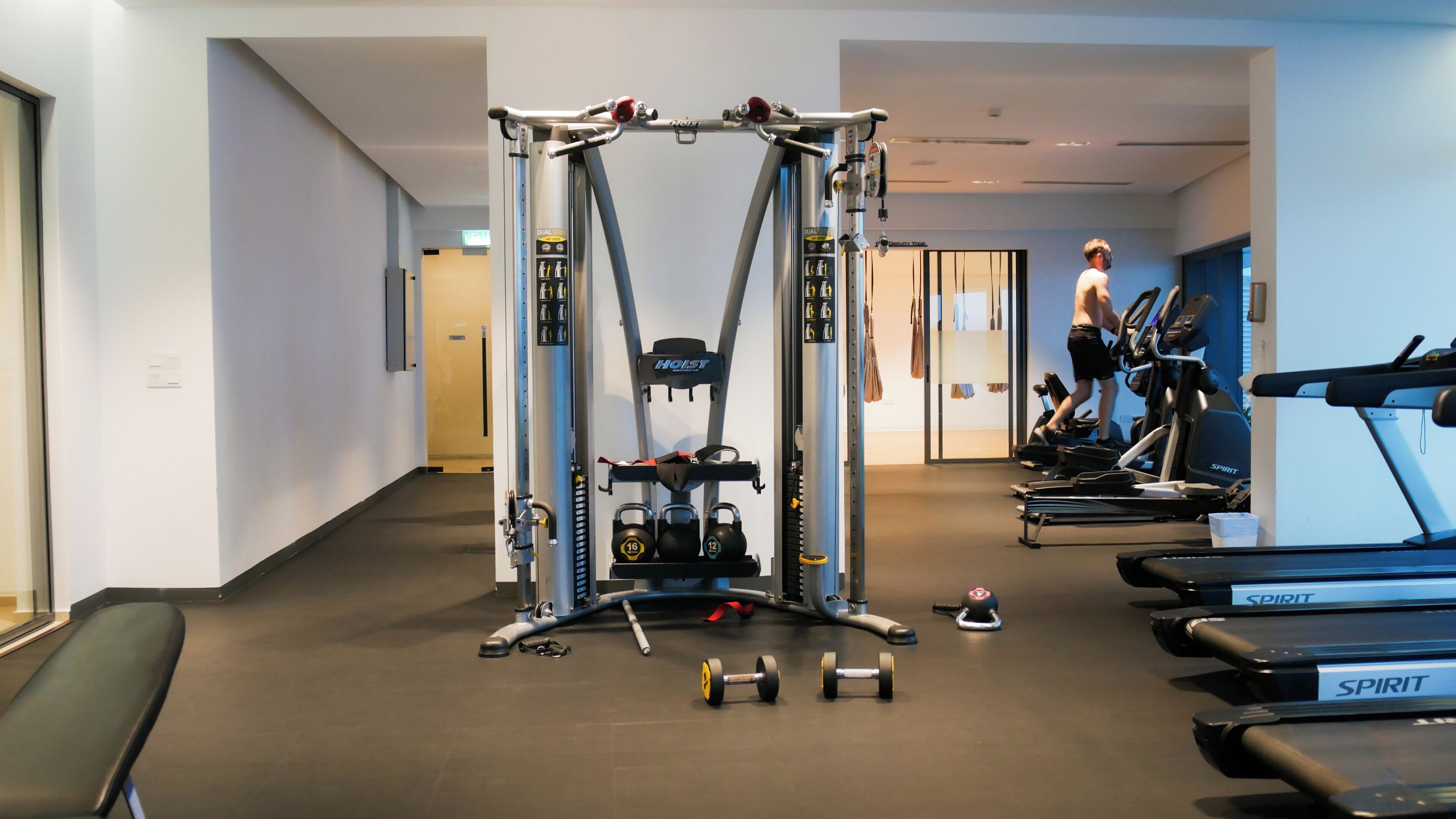 A gym with exercise equipment, treadmills, and dumbbells.