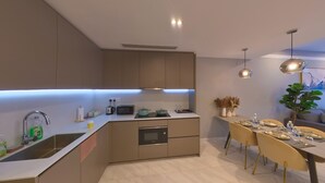 Uma cozinha moderna com forno embutido, micro-ondas e um espaço de refeições com mesa posta para quatro pessoas.