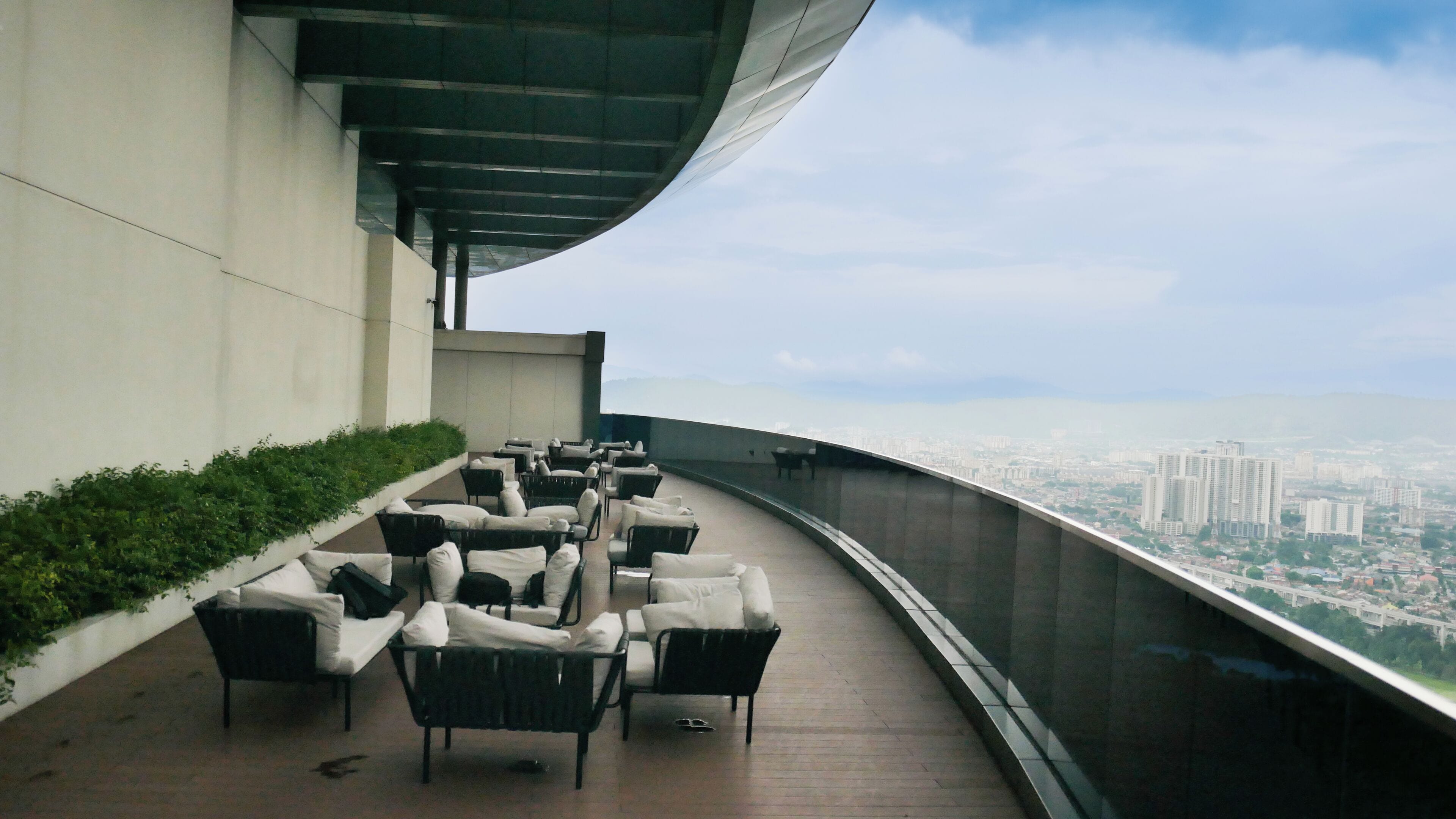 A rooftop terrace with outdoor seating and a city view.