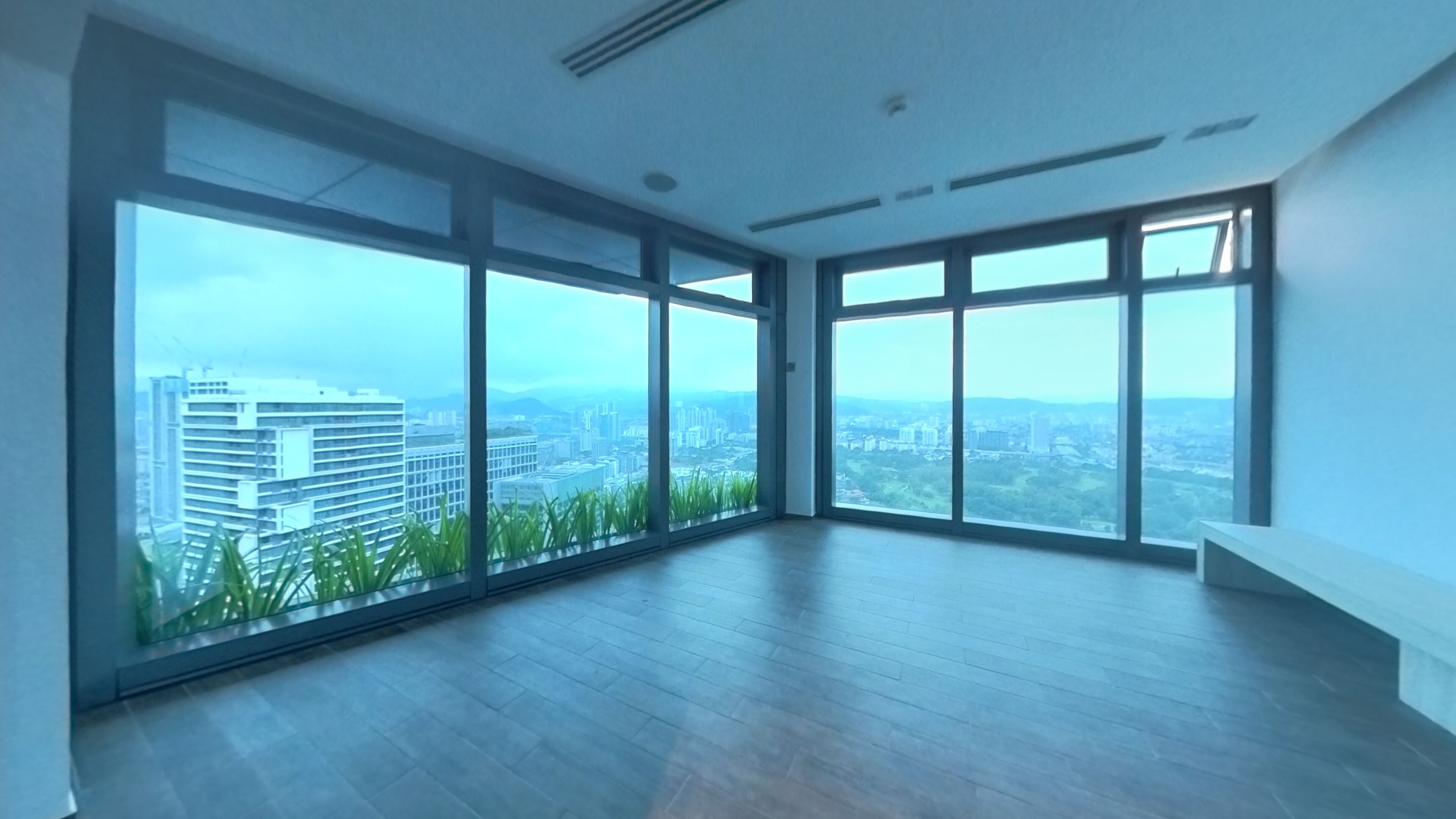 Amplia habitación con grandes ventanales y vistas a la ciudad.