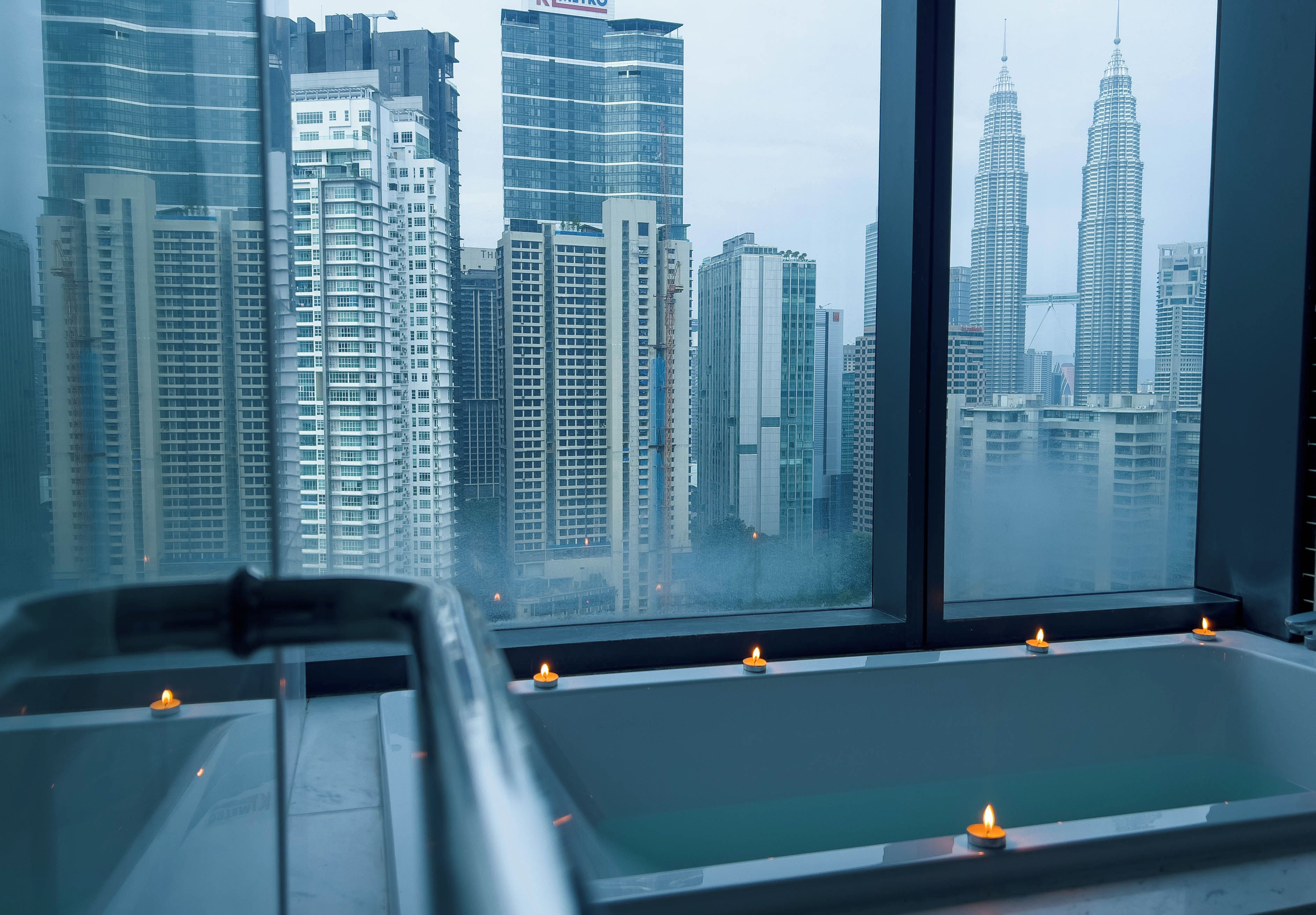 A room with a large window overlooking a cityscape with high-rise buildings.