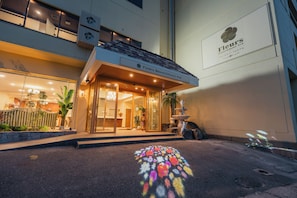 A hotel entrance with a sign for 'Fleurs Resort & Hotel' and a decorative fountain.