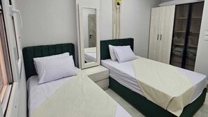 Una camera da letto moderna con due letti, un armadio e uno specchio.