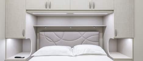 A bedroom with a bed, nightstands, and built-in cabinets.
