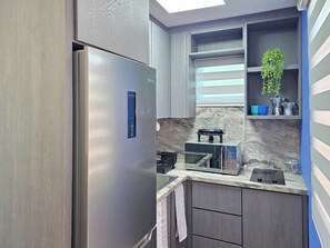 A modern kitchen with a built-in refrigerator, a microwave, and a stove. - Palmera Azul | Cozy Private Apartment in Cabo Rojo (Cabo Rojo)